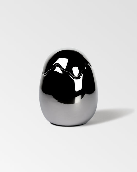 Silver mirror-finished Ovonique ceramic candle jar with sculptural egg shape on white background