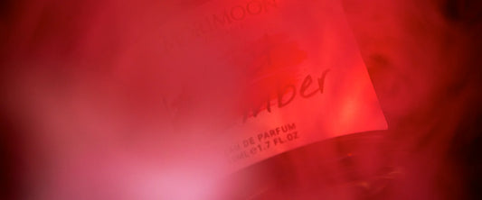 Velvet Ember fragrance in deep crimson light, evoking a silent fire and sensual warmth.